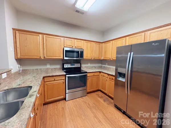 a kitchen with stainless steel appliances granite countertop a refrigerator microwave and sink
