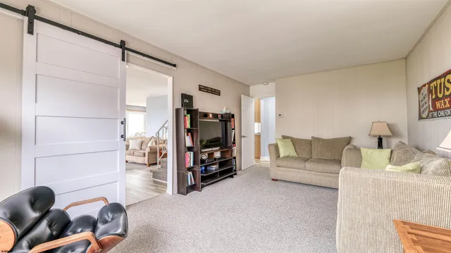 a living room with furniture a large window and a flat screen tv