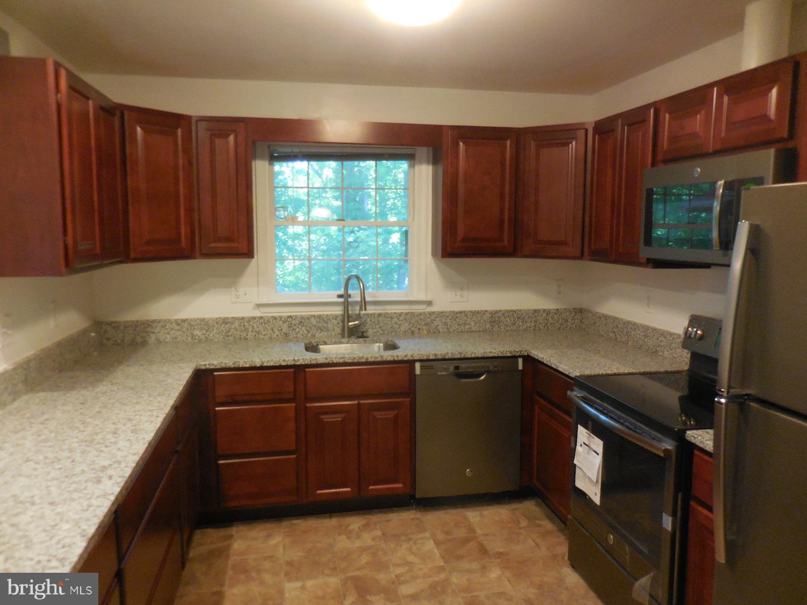 508 Holly Road Fort Washington, MD 20744 - Photo 5 of 29 a kitchen with stainless steel appliances granite countertop a sink stove and refrigerator