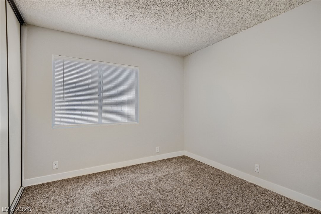 2343 Valleywood Road Henderson, NV 89014 - Photo 12 of 29 A well-lit bedroom provides a cozy retreat with soft carpeting and functional window blinds.