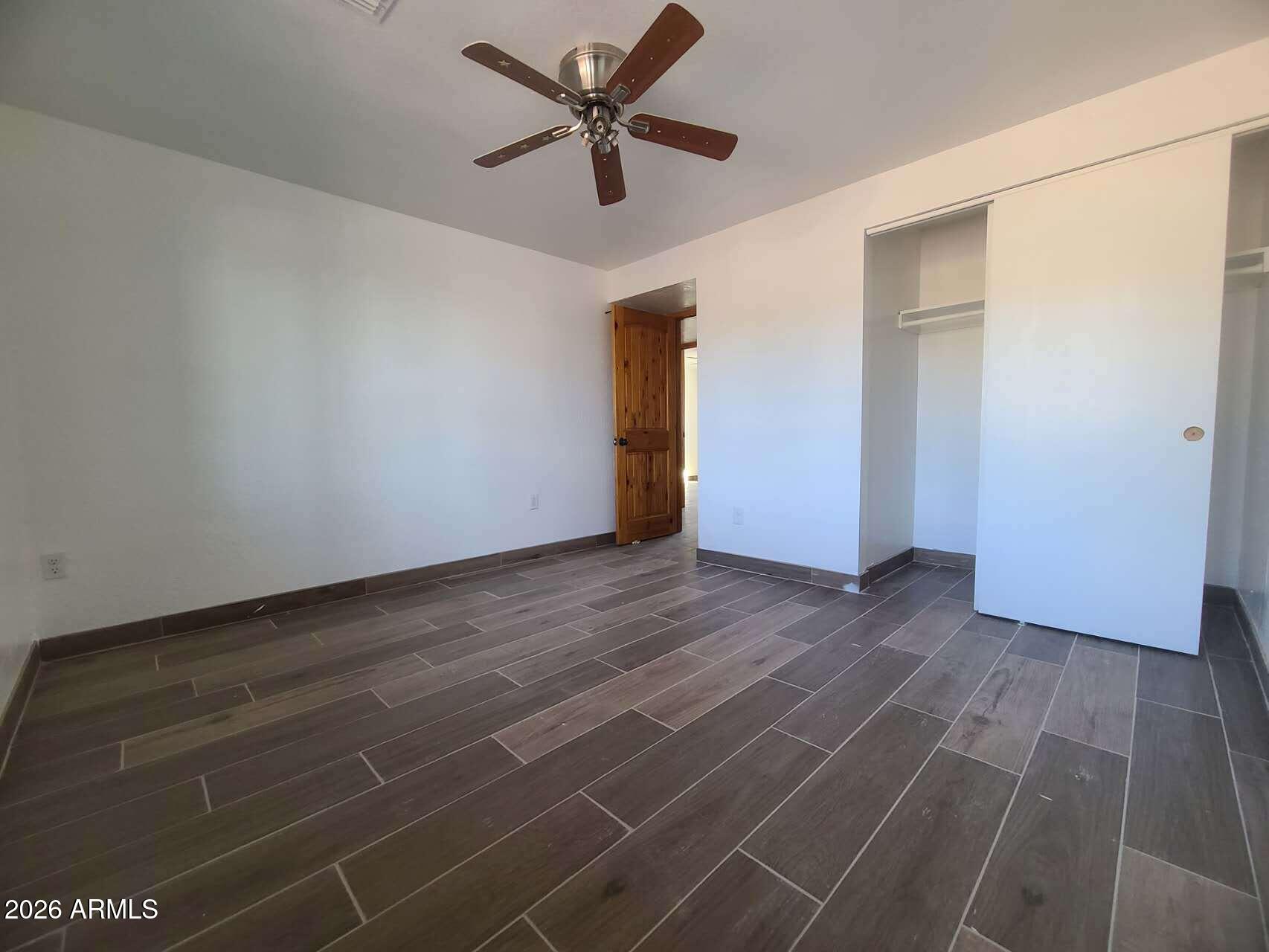 3702 East Thunderbird Road Phoenix, AZ 85032 - Photo 12 of 23 a view of a livingroom with wooden floor and a ceiling fan