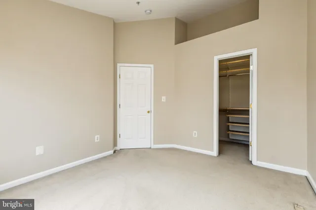 a view of an empty room with closet and washing machine