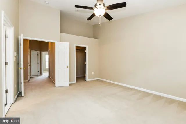 an empty room with closet and a ceiling fan