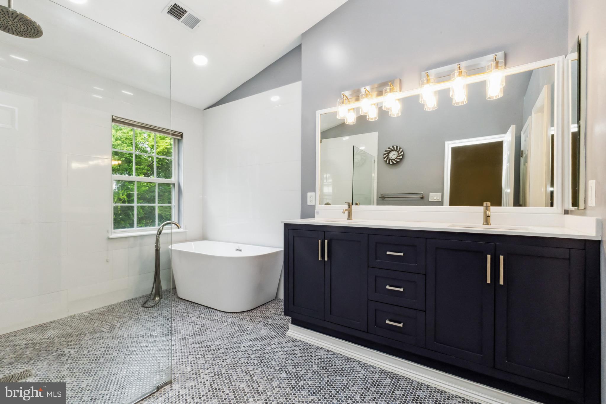 49 Inkberry Circle Gaithersburg, MD 20877 - Photo 18 of 25 a bathroom with a tub sink double vanity and mirror