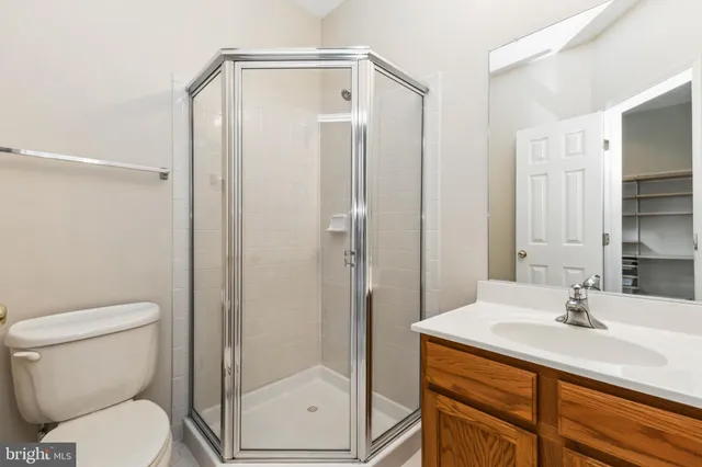 a bathroom with a shower sink vanity mirror and toilet