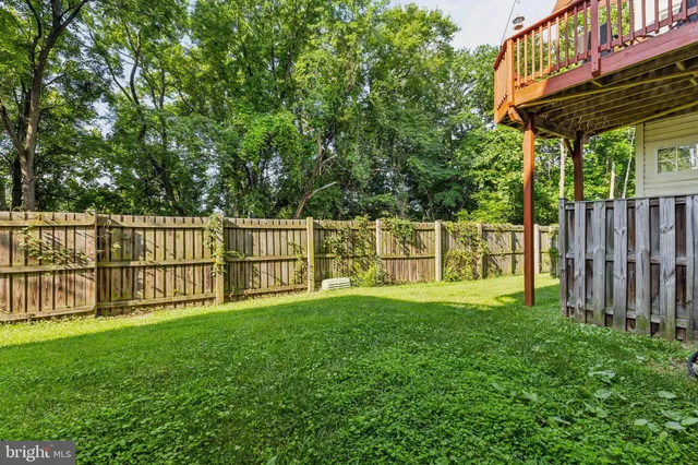 a view of a yard with wooden fence and a bench