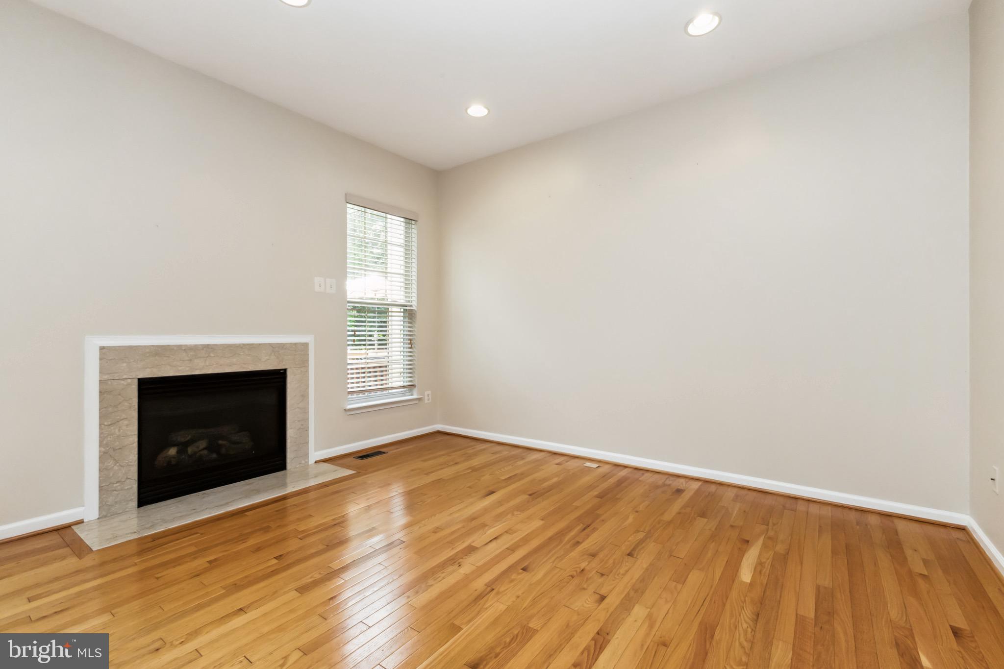 49 Inkberry Circle Gaithersburg, MD 20877 - Photo 5 of 25 a view of an empty room with wooden floor fireplace and a window