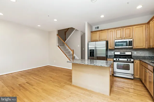 a kitchen with granite countertop a stove top oven and sink