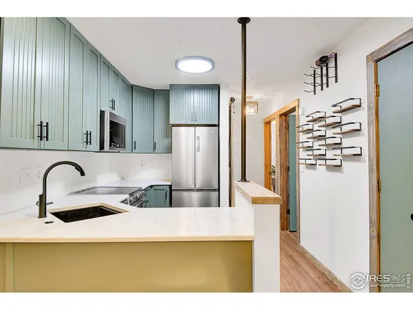 a kitchen with stainless steel appliances granite countertop a sink a stove and refrigerator