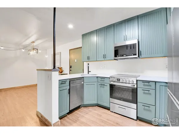 a kitchen with stainless steel appliances granite countertop a stove a microwave and a sink