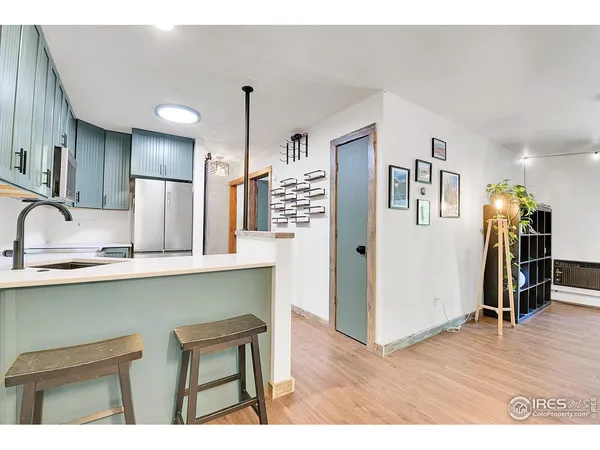 a kitchen with stainless steel appliances granite countertop a sink a stove a refrigerator and island with wooden floor