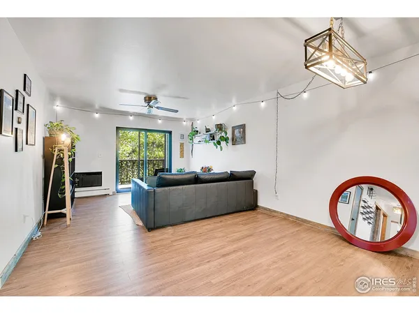 a living room with furniture a window and wooden floor