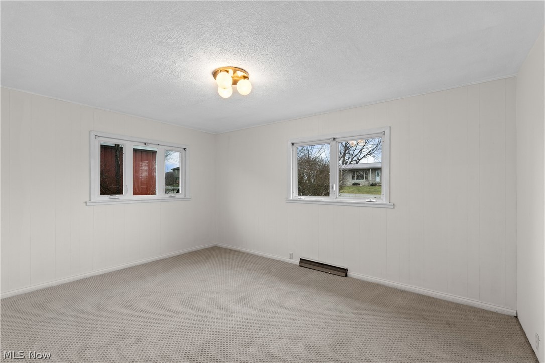 70828 Crescent Road St. Clairsville, OH 43950 - Photo 20 of 40 Spare room featuring light colored carpet, a baseboard heating unit, and a textured ceiling