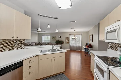 a kitchen with stainless steel appliances kitchen island granite countertop a sink stove cabinets and wooden floor