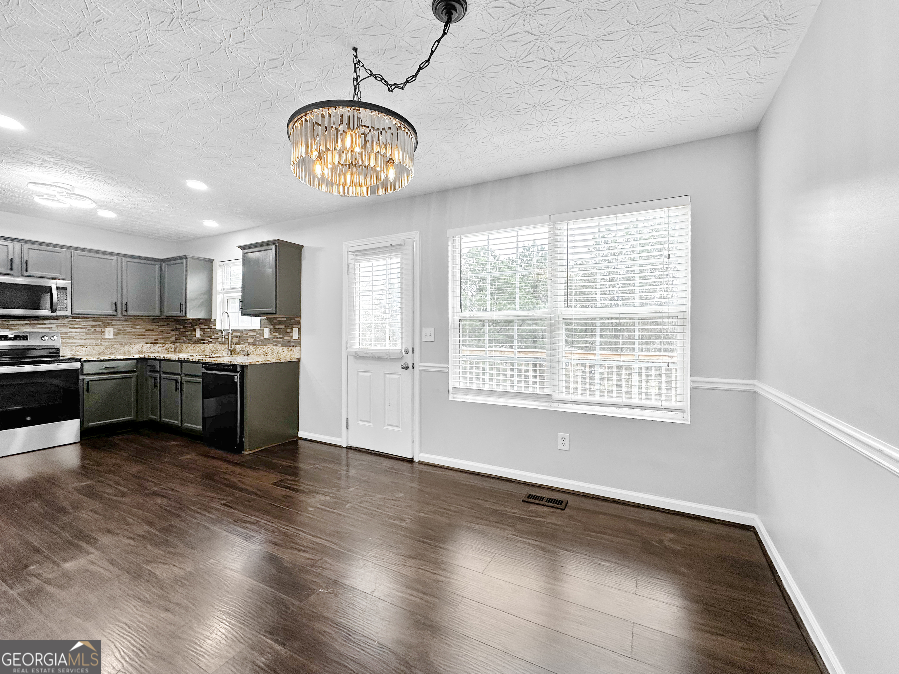 105 Aprils Way Union City, GA 30291 - Photo 5 of 20 a open kitchen with stainless steel appliances granite countertop a stove a sink dishwasher a refrigerator and a dining table with wooden floor