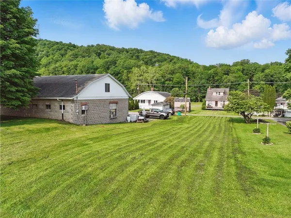 a aerial view of a house with swimming pool garden view and a large tree
