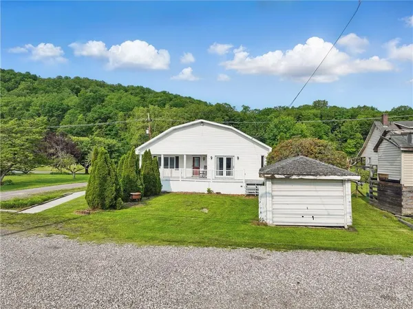 a front view of a house with yard and green space