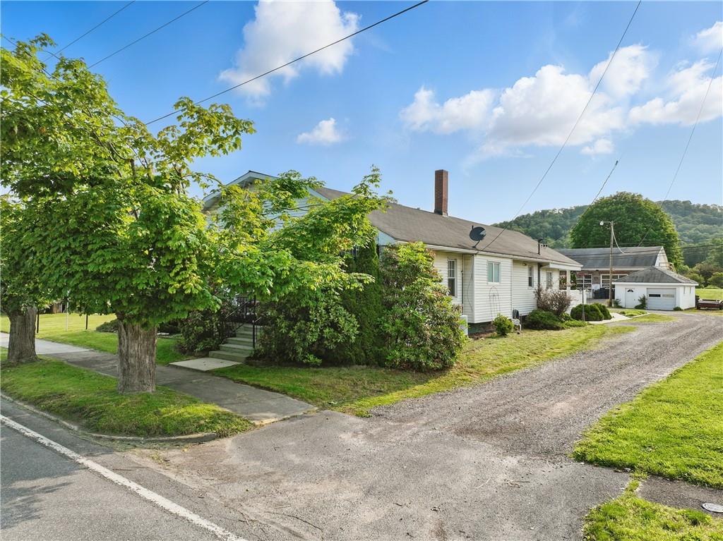 833 Oden Street Confluence, PA 15424 - Photo 16 of 48 a front view of a house with a yard and a garden
