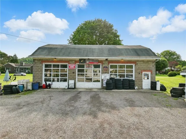 a view of a house with a yard and parking space
