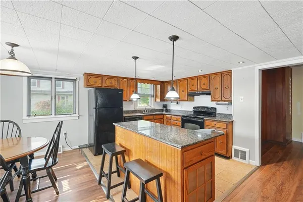 a kitchen with stainless steel appliances granite countertop a kitchen island a table and chairs in it
