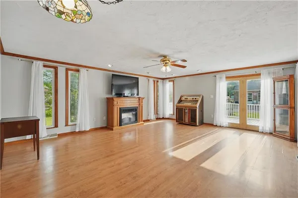a view of a livingroom with furniture wooden floor staircase and windows