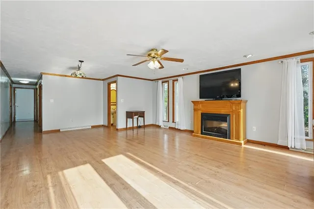 a view of an empty room with window and fireplace