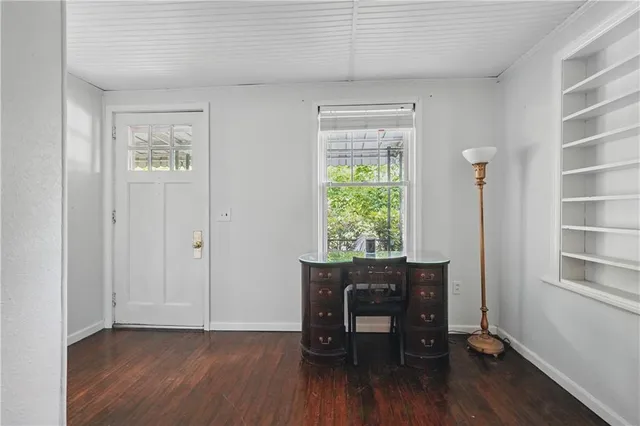 a view of a workspace with furniture and a window