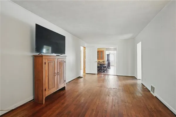 a view of a livingroom with wooden floor and a flat screen tv