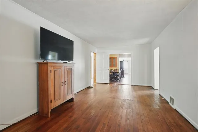 a view of a livingroom with wooden floor and a flat screen tv