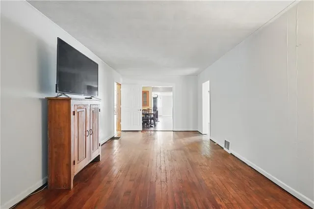 a view of a livingroom with wooden floor and a flat screen tv