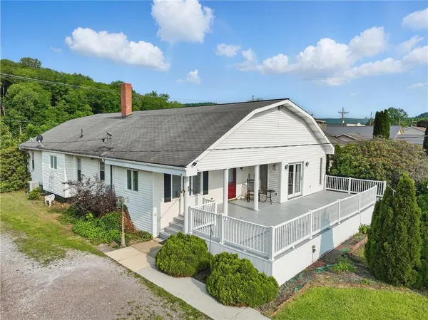 a view of house with a yard and potted plants