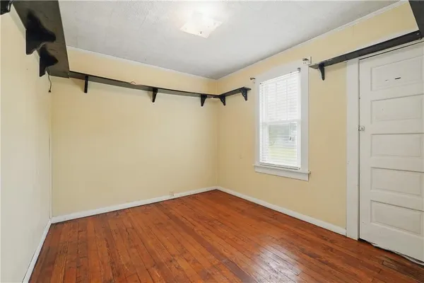 a view of a room with wooden floor and brick walls
