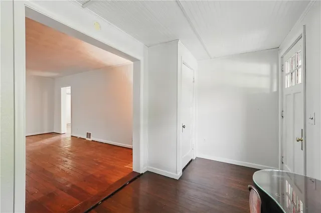 an empty room with wooden floor and closet