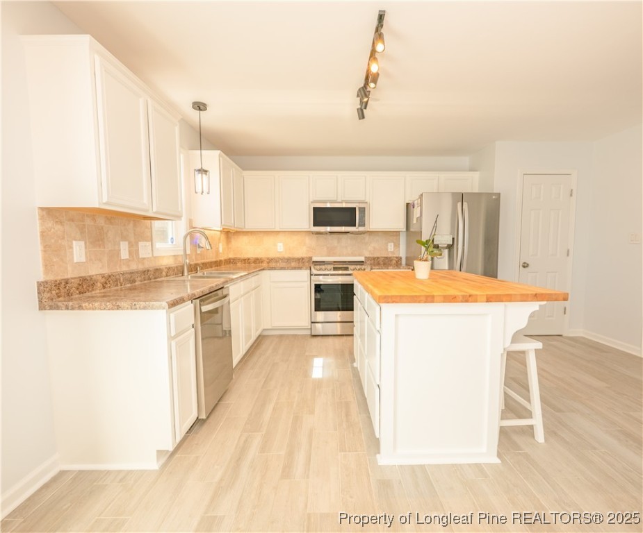 2112 Yellowbrick Road Fayetteville, NC 28314 - Photo 12 of 48 a kitchen with a sink a stove cabinets and a dining table