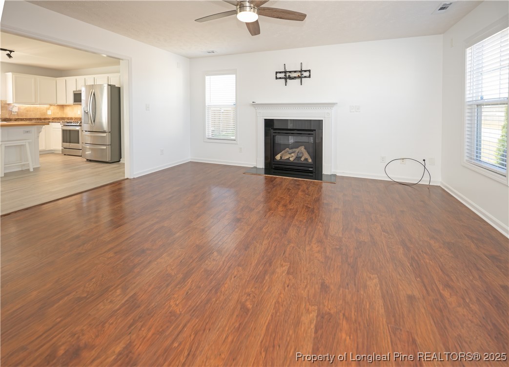 2112 Yellowbrick Road Fayetteville, NC 28314 - Photo 4 of 48 an empty room with wooden floor a fireplace and windows