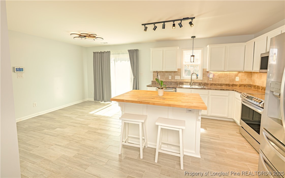 2112 Yellowbrick Road Fayetteville, NC 28314 - Photo 8 of 48 a kitchen with kitchen island a sink cabinets and wooden floor