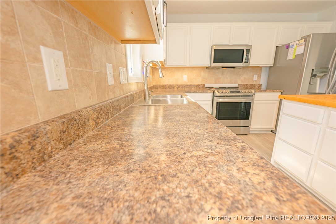 2112 Yellowbrick Road Fayetteville, NC 28314 - Photo 10 of 48 a kitchen with stainless steel appliances a stove a sink and a refrigerator