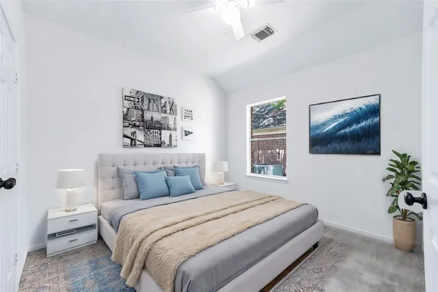 a view of a house with a small yard and a large tree