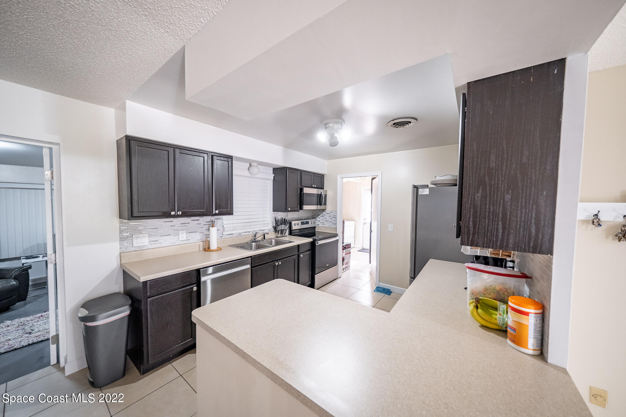 982 Cardon Drive Rockledge, FL 32955 - Photo 12 of 27 a kitchen with stainless steel appliances kitchen island granite countertop a sink and cabinets