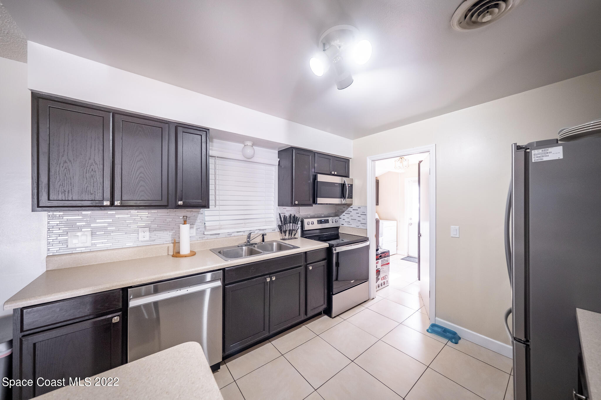 982 Cardon Drive Rockledge, FL 32955 - Photo 14 of 27 a kitchen with a sink a refrigerator and cabinets