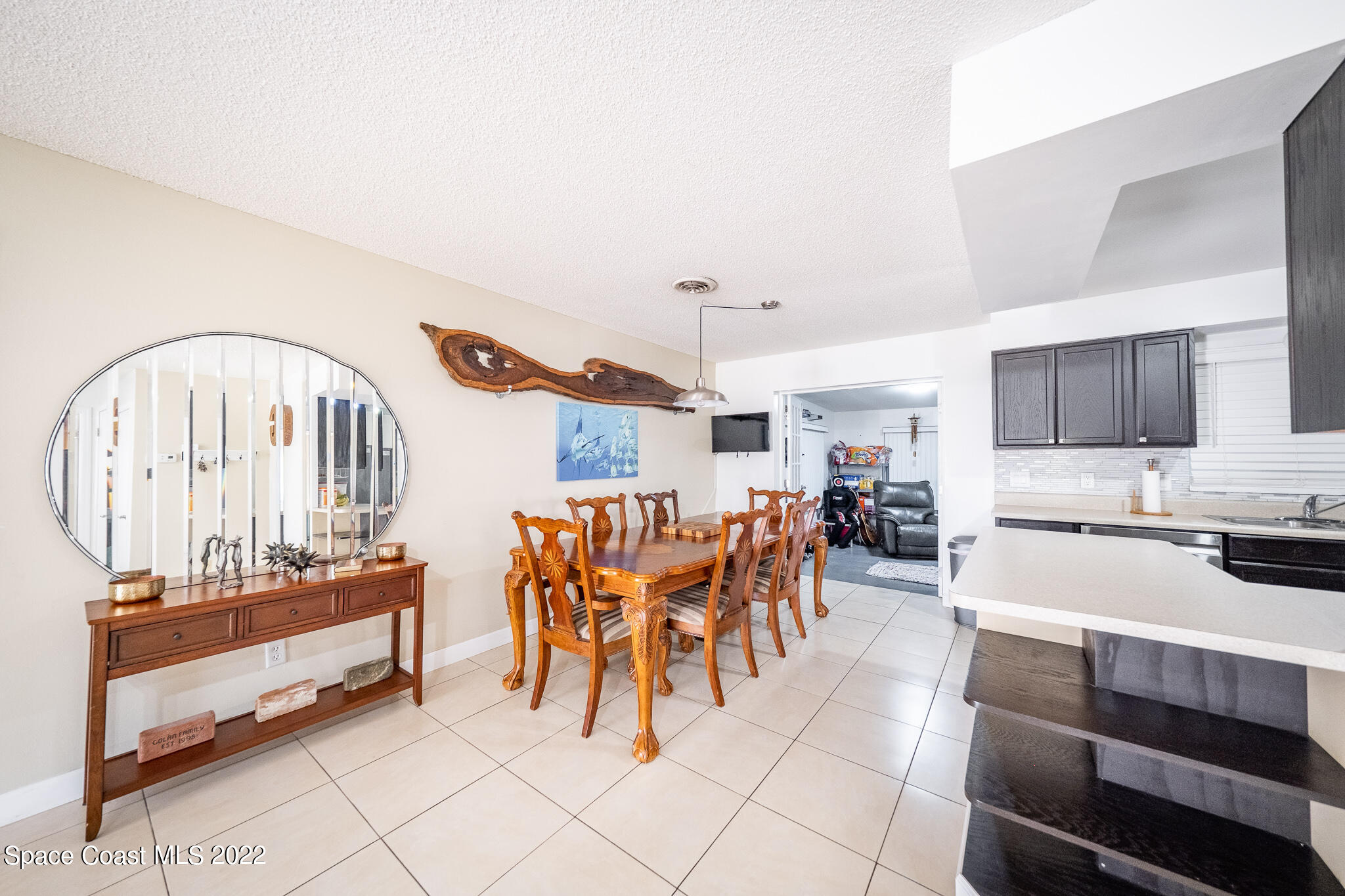 982 Cardon Drive Rockledge, FL 32955 - Photo 9 of 27 a living room with furniture a flat screen tv and kitchen view