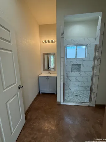 a bathroom with a granite countertop toilet and a sink