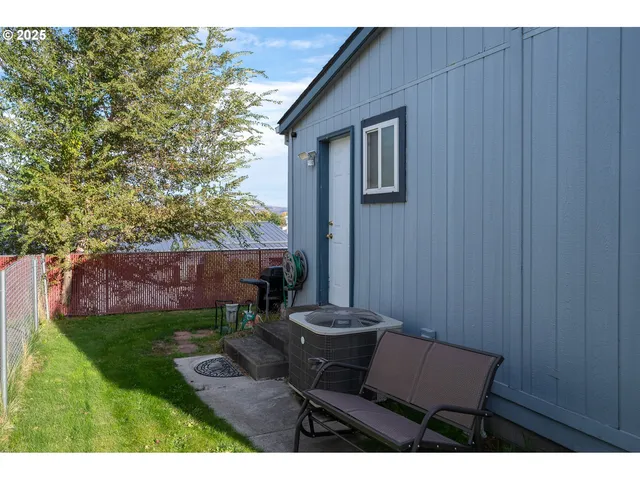 a backyard of a house with table and chairs