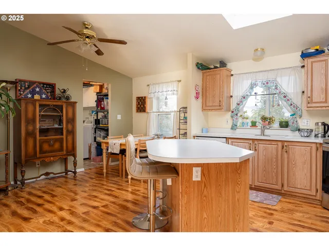 a dining hall with stainless steel appliances granite countertop a dining table chairs and a refrigerator