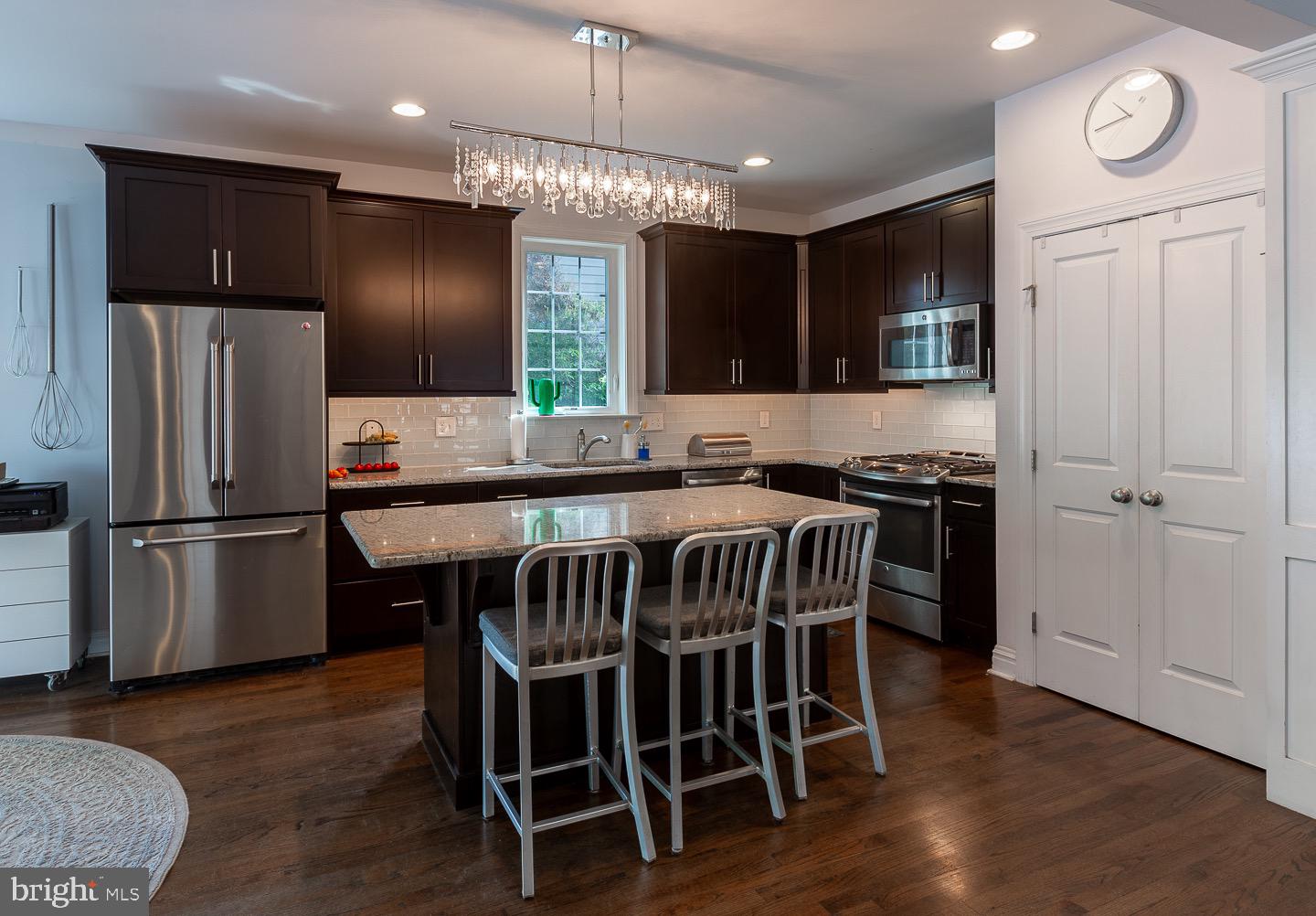 326 Kenmore Road Havertown, PA 19083 - Photo 13 of 74 a kitchen with stainless steel appliances granite countertop a stove a refrigerator a microwave a sink and a dining table with wooden floor