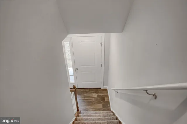a view of a closet area with wooden floor