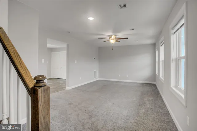 a view of a room with a ceiling fan and window