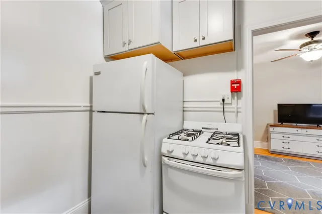 a white refrigerator freezer and a stove sitting inside of a kitchen