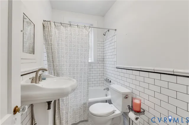 a bathroom with a sink a toilet and shower curtain