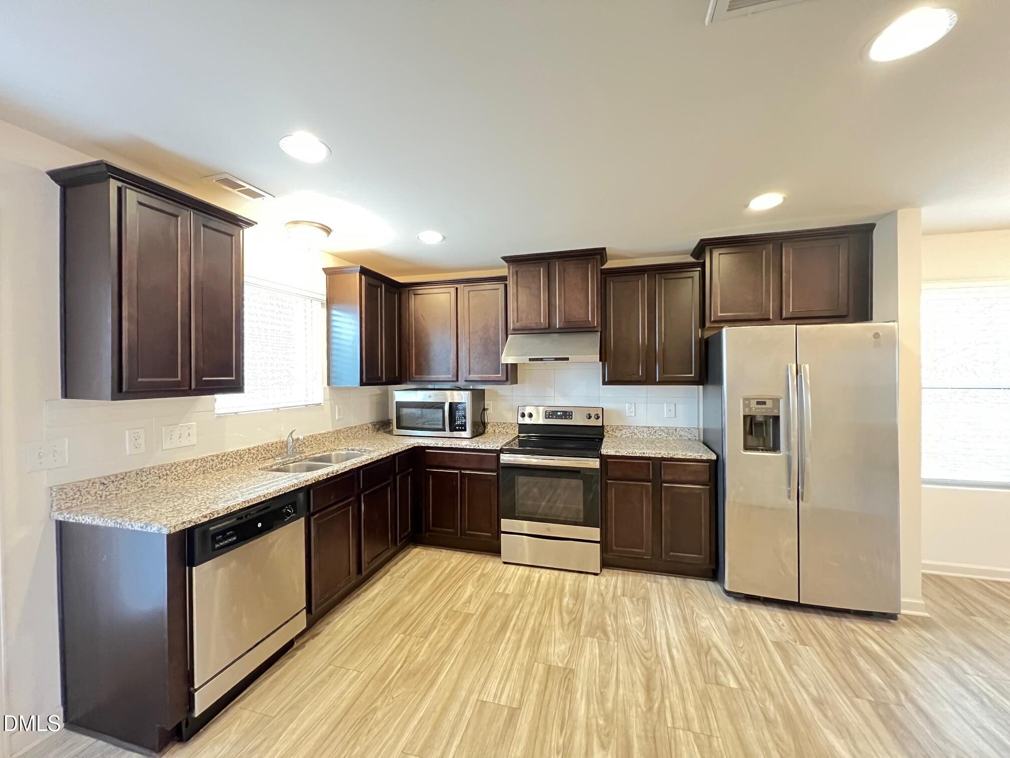 18 Rochambeau Court Durham, NC 27704 - Photo 2 of 12 a kitchen with stainless steel appliances granite countertop a stove a sink dishwasher a refrigerator and a oven with wooden floor